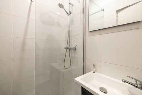ein weißes Bad mit einer Dusche und einem Waschbecken in der Unterkunft Sublime studio renovated - Cannes center in Cannes