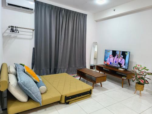 a living room with a couch and a flat screen tv at New Cozy The Sun Homestay at Sg Nibong Bayan Lepas Factory Area in Bayan Lepas
