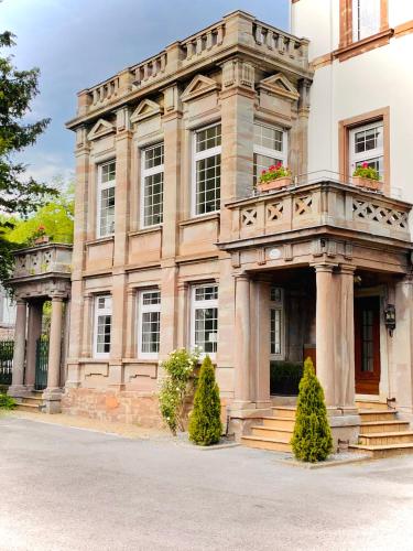 a large stone building with a balcony on a street at Ferienwohnung Honeymoon Deluxe Wellness mit Sauna auf Schloss Falkenhorst in Kleinblittersdorf