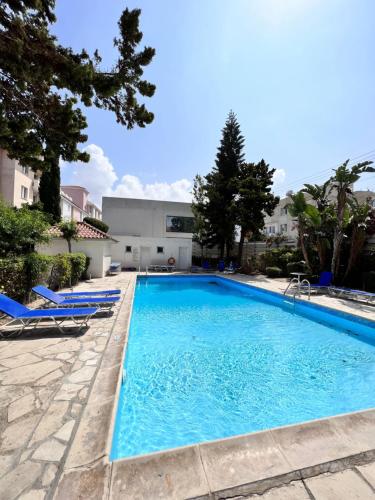 a swimming pool with blue water in a yard at Pafia Sunbeach Townhouse in Paphos