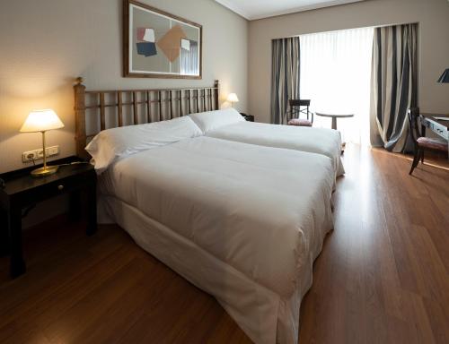 a large white bed in a hotel room at Barceló León Conde Luna in León