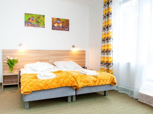 1 dormitorio con 1 cama grande con manta amarilla en Gościniec Ptasi Zaułek, en Niechorze