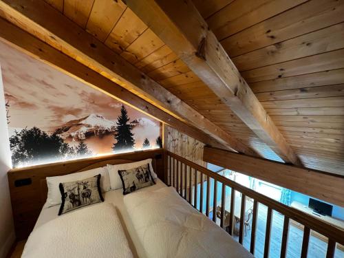 uma cama num quarto com tecto em madeira em KAISERKRONE CHARMING RETREAT em Dimaro