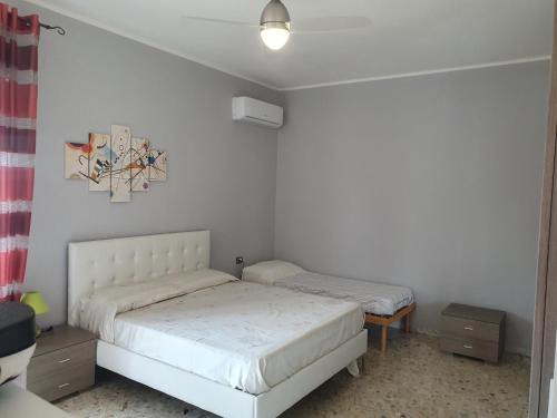 - une chambre avec 2 lits et un tableau mural dans l'établissement Attico Due Giugno, à Piombino