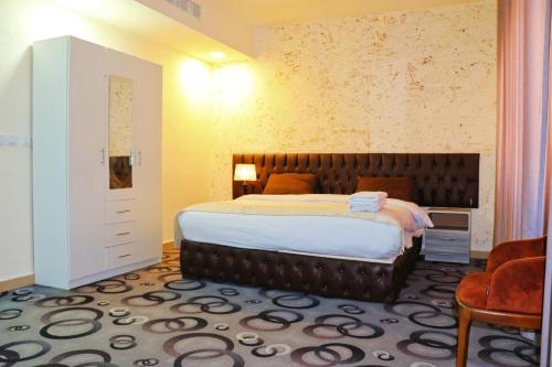 ein Schlafzimmer mit einem großen Bett und einem Stuhl in der Unterkunft Skylight apartments in Amman