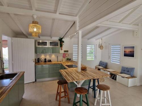 a kitchen with a wooden table and some chairs at Villa Eden, à 400 mètres de la plage du Souffleur in Port-Louis