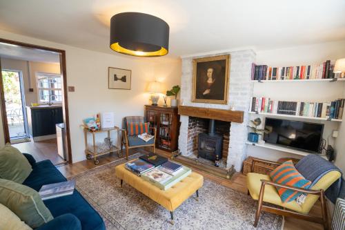 a living room with a couch and a fireplace at Hall Cottage Bramfield Suffolk in Bramfield