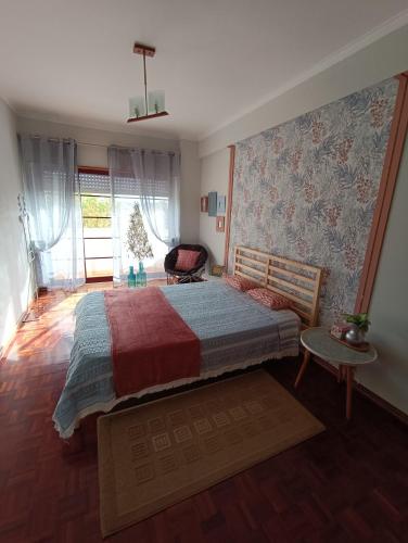 a bedroom with a large bed and a window at GREEN GARDEN APARTMENT IN ODIVELAS in Odivelas
