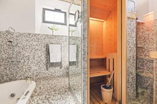 a bathroom with a tub and a glass shower at Casa Doria by Burghesius in Rome