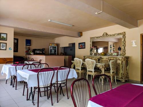 una sala da pranzo con tavoli, sedie e specchio di Pension Casa Samurai a Braşov