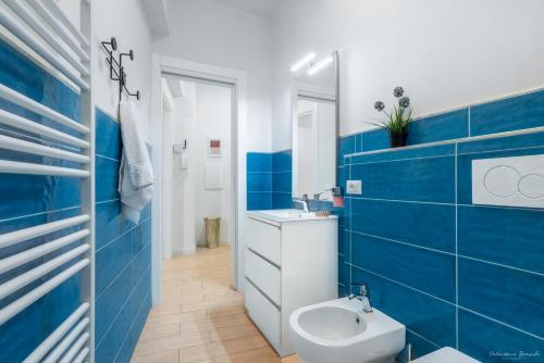 uma casa de banho azul e branca com um lavatório e um WC em Wine Apartments Florence Masseto em Florença
