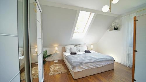 a white bedroom with a bed in a attic at Apartamenty Every Sky Nad Łomnicą 1b-6b in Karpacz
