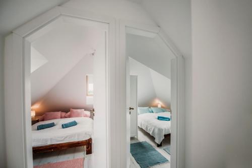 a bedroom with two beds and a mirror at Pécs City View- free parking in Pécs