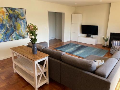 a living room with a couch and a tv at Casa em Cascais in Cascais