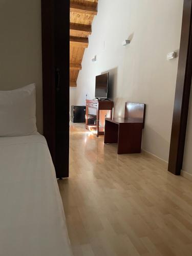 a bedroom with a bed and a desk and a tv at Silken Ordesa in Torla