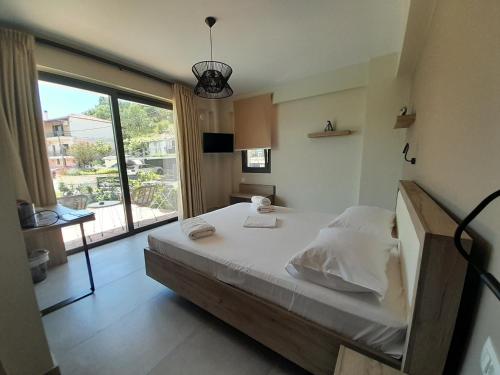 a bedroom with a large bed and a large window at MARIVAL Luxury Living - Adults Only in Sivota