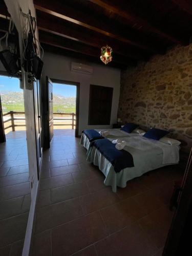 a bedroom with two beds and a large window at Habitacion rural en Alora Caminito del Rey in Málaga