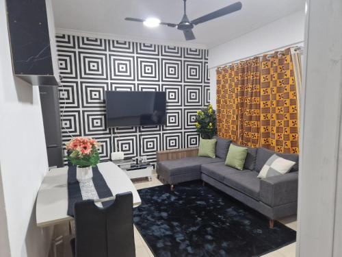 ein Wohnzimmer mit einem Sofa und einem TV in der Unterkunft KESEWAA's APARTMENT in Accra