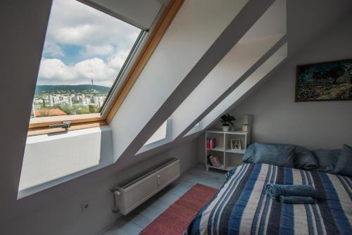 1 dormitorio con cama y ventana grande en Pécs City View- free parking en Pécs