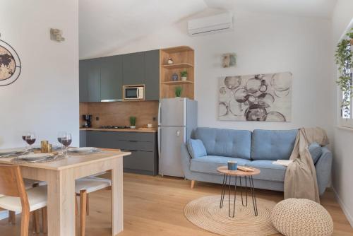 a living room with a blue couch and a kitchen at Cozy Apartment - 100m from the beach Punta in Pakoštane