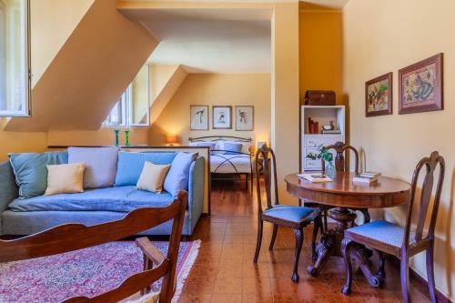 ein Wohnzimmer mit einem blauen Sofa und einem Tisch in der Unterkunft Gothic Apartments by Wonderful Italy in Bellagio