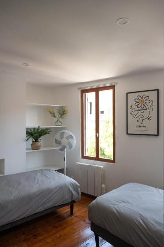 une chambre avec deux lits et une fenêtre dans l'établissement Redbrick’s Bergerac, Au coeur du centre historique, à Bergerac