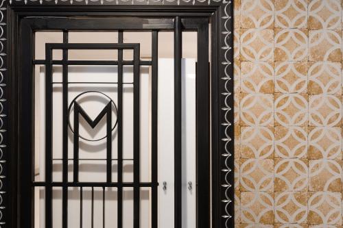 a black door with a m logo on it at Sirin Exclusive Hotel and Residence in Pattaya South