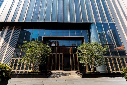 an entrance to a building with trees in front of it at Canopy Executive Apartments - Shenzhen Futian Center in Shenzhen