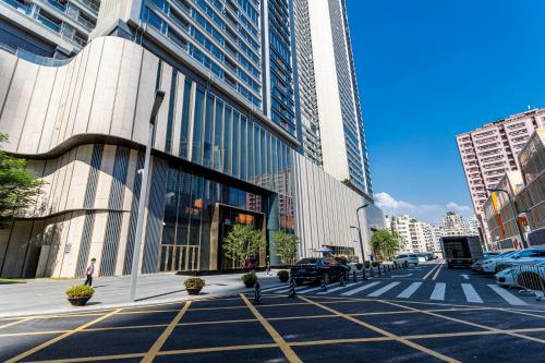 una strada cittadina con un edificio con auto parcheggiate sopra di Canopy Executive Apartments - Shenzhen Futian Center a Shenzhen