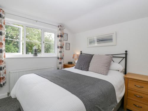 a bedroom with a bed and two windows at 4 Wallflower Row in Hereford