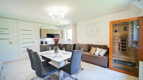 a kitchen and living room with a table and a couch at Apartamenty Every Sky Nad Łomnicą 1b-6a in Karpacz