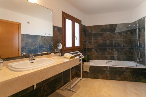 uma casa de banho com um lavatório e uma banheira em Sa Marina des torrent em Ses Salines