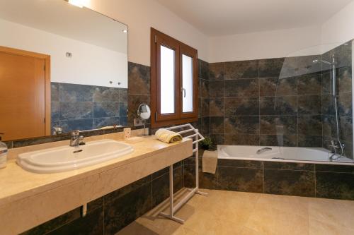 a bathroom with a sink and a bath tub at Sa Marina des torrent - Grupo Berna in Ses Salines