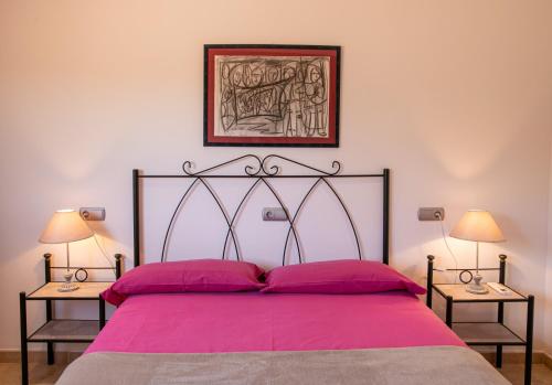 um quarto com uma grande cama rosa e 2 candeeiros em Sa Marina des torrent em Ses Salines