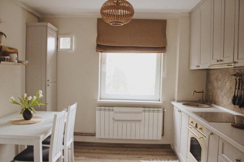 a kitchen with a table and chairs and a window at Cetate boulevard Apartment in Alba Iulia