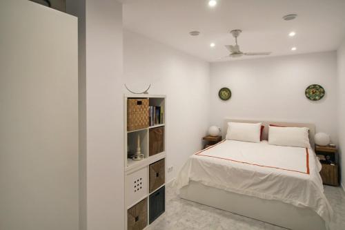 a white bedroom with a bed and a book shelf at Ground Floor Bellaluz Apartment - La Manga Club in Atamaría