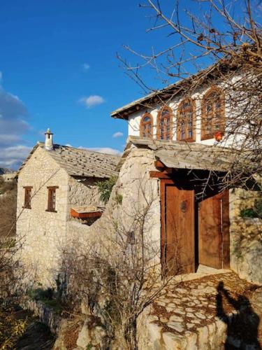 una antigua casa de piedra con puerta de madera en Bosnian National Monument Počitelj - Muslibegovic Summer House en Čapljina