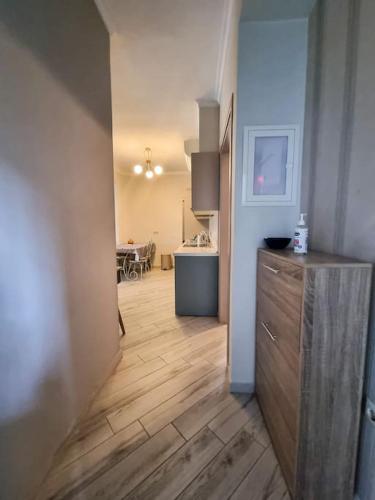 Un pasillo con una cocina y una sala de estar con suelo de madera. en Luxury & Modern Apartment, en Paralia Katerinis