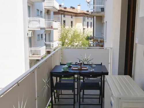 a small balcony with a black table and chairs on it at Wind Rose House - bicamere, parcheggio fronte mare in Grado
