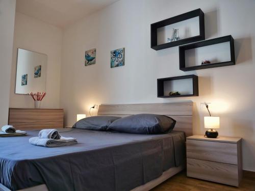 a bedroom with a bed with two monitors on the wall at Wind Rose House - bicamere, parcheggio fronte mare in Grado