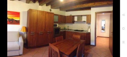 a kitchen with wooden cabinets and a wooden table at Appartamento centro Lecco in Lecco