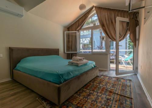 a bedroom with a bed and a large window at Forest Cottage - middle of forest & near the beach in Golem