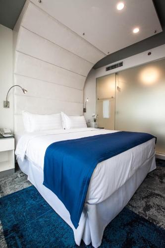 a bedroom with a large bed with a blue blanket at Wyndham Garden Brooklyn Sunset Park in Brooklyn