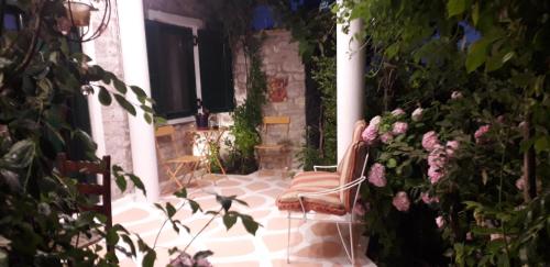 a patio with a chair and flowers at Studio Penelope in Kerasochórion