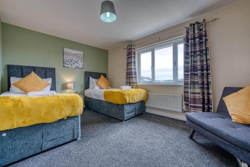 - une chambre avec 2 lits, un canapé et une fenêtre dans l'établissement Coventry Team Accomodation with Private Parking & WIFI, à Parkside