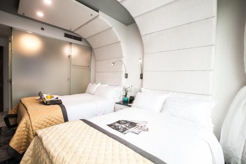 two beds in a room with white walls at Wyndham Garden Brooklyn Sunset Park in Brooklyn