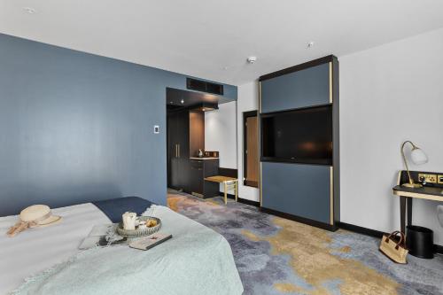 a hotel room with a bed and a large television at Mercure Paignton Hotel in Paignton