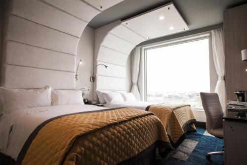 a bedroom with two beds and a large window at Wyndham Garden Brooklyn Sunset Park in Brooklyn