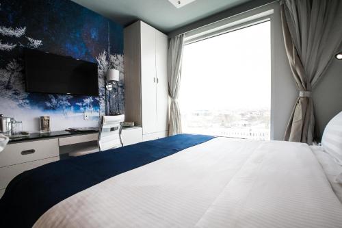 a bedroom with a large bed with a large window at Wyndham Garden Brooklyn Sunset Park in Brooklyn