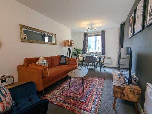 ein Wohnzimmer mit einem Sofa und einem Tisch in der Unterkunft Beautiful Modern Coventry City Centre Apartment in Coventry
